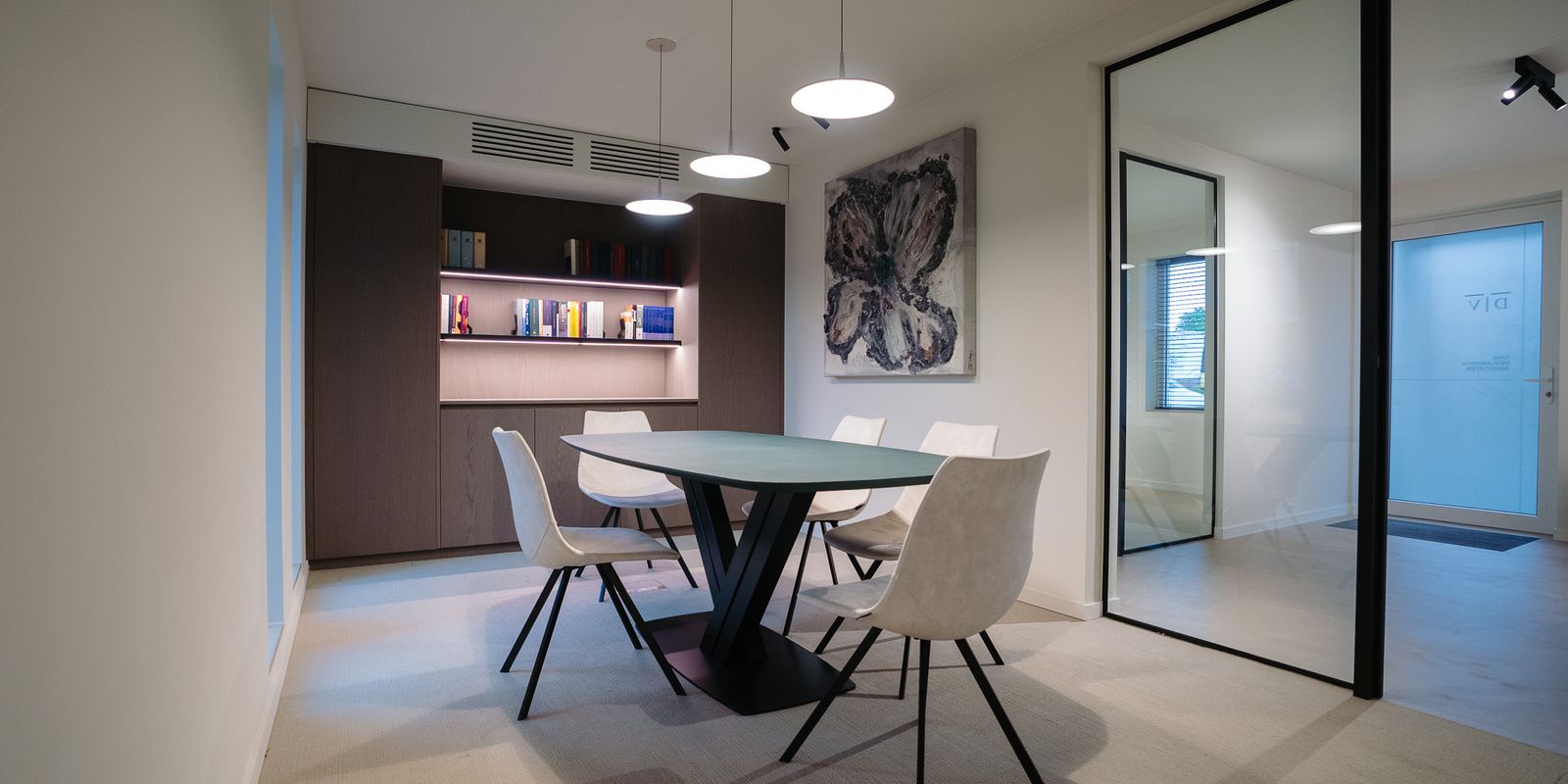 Een lege vergaderruimte, met op de achtergrond een boekenkast